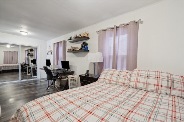 bedroom with dark wood-type flooring and a closet