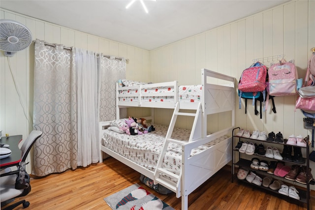 bedroom featuring hardwood / wood-style floors and wood walls