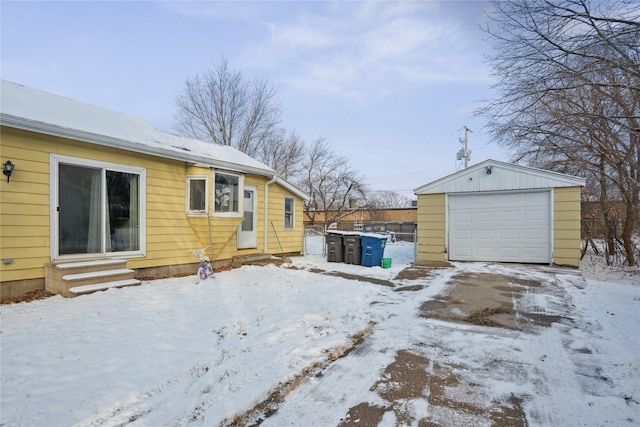 snow covered property with an outbuilding and a garage