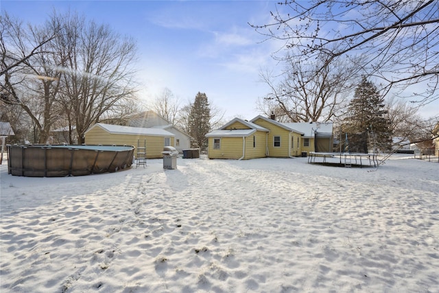 yard covered in snow featuring a trampoline