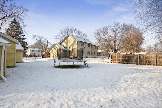 yard covered in snow with a trampoline