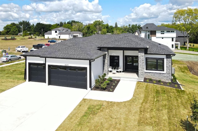 view of front facade featuring covered porch, a front yard, and a garage