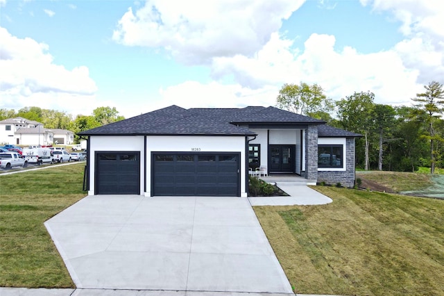 prairie-style house featuring a front yard and a garage