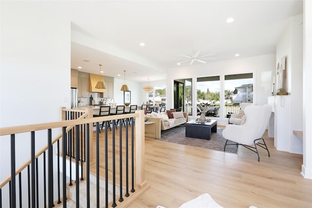 living room featuring ceiling fan and light hardwood / wood-style flooring