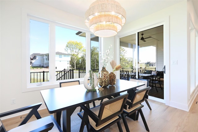 dining area with a notable chandelier and light hardwood / wood-style flooring