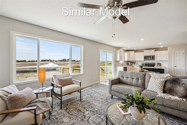 living room with carpet flooring, plenty of natural light, ceiling fan, and sink