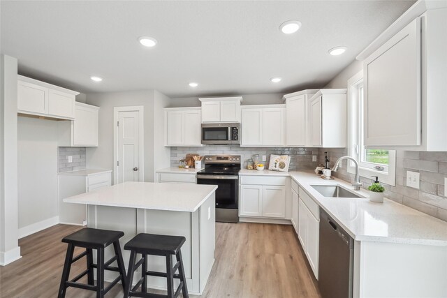 3251 NW Brookside Dr, Grimes, IA 50111 - kitchen featuring stainless steel appliances, a sink, a center island, decorative backsplash, and recessed lighting