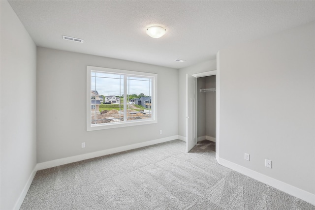 3251 NW Brookside Dr, Grimes, IA 50111 - unfurnished bedroom with carpet, baseboards, a closet, and a textured ceiling