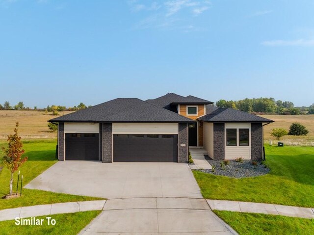 prairie-style home with a garage and a front yard