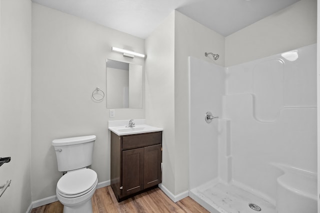 bathroom with toilet, a shower, wood-type flooring, and vanity