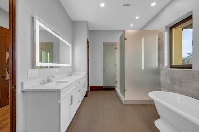 bathroom featuring vanity, independent shower and bath, and tile walls