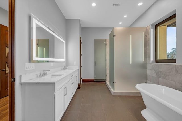 7217 NW 107th St, Johnston, IA 50131 - bathroom featuring a stall shower, double vanity, a freestanding bath, and recessed lighting