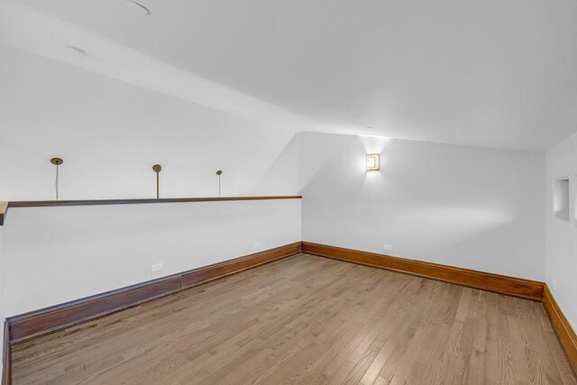 bonus room featuring lofted ceiling and light wood-type flooring