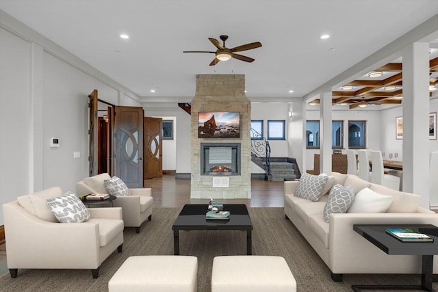 living room with beamed ceiling, ceiling fan, a fireplace, and dark hardwood / wood-style flooring