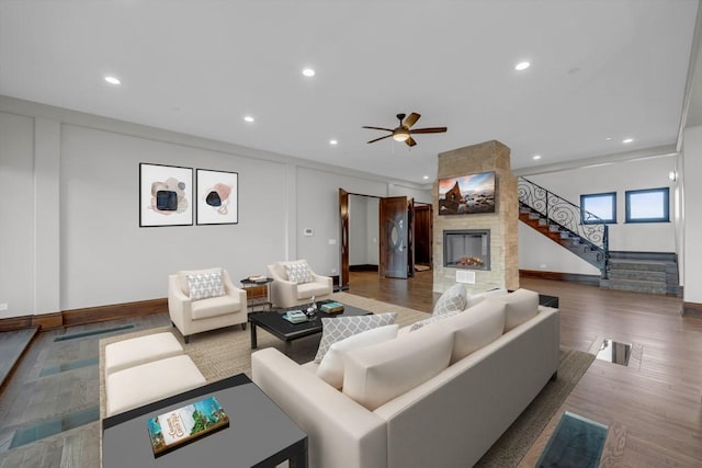 living room with crown molding, ceiling fan, a fireplace, and hardwood / wood-style floors