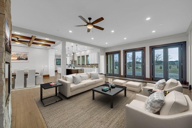 living room with ceiling fan, light hardwood / wood-style flooring, french doors, and beamed ceiling