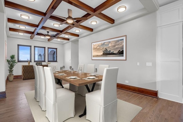 dining area with beam ceiling, coffered ceiling, ceiling fan, and light hardwood / wood-style flooring