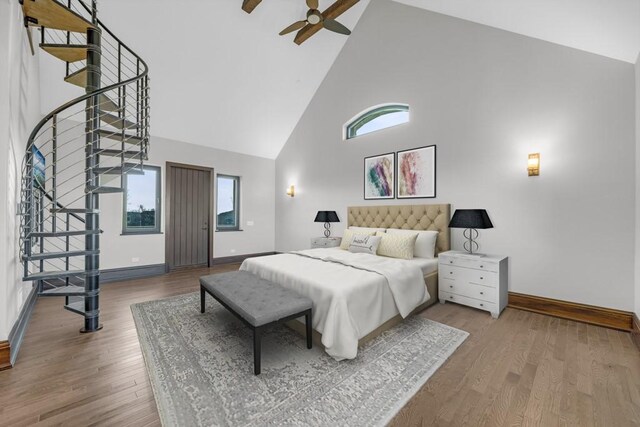 bedroom featuring ceiling fan, high vaulted ceiling, multiple windows, and light wood-type flooring