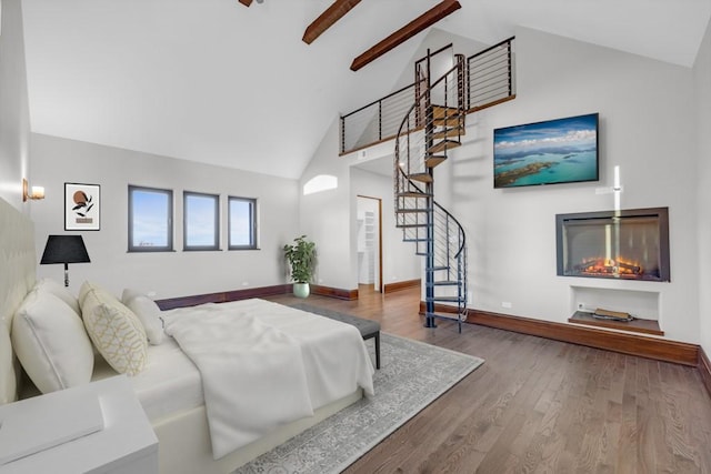 bedroom featuring hardwood / wood-style floors, beam ceiling, and high vaulted ceiling