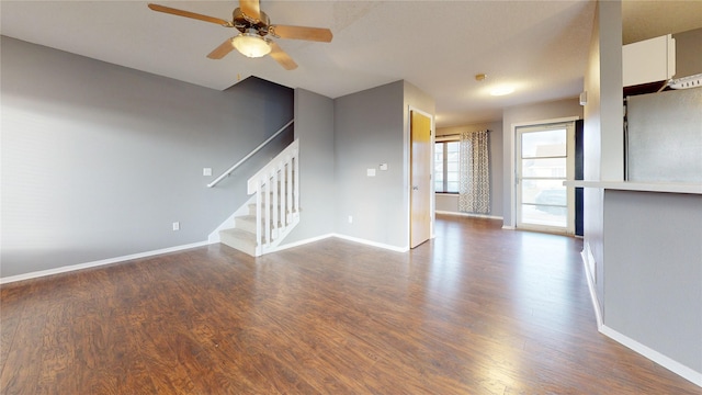 unfurnished living room with ceiling fan and dark wood-type flooring