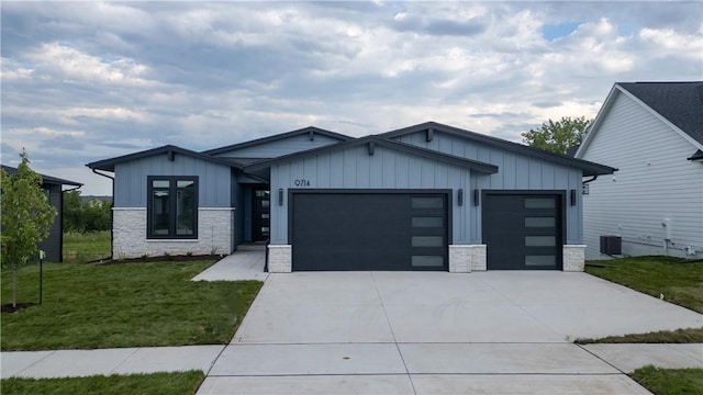 view of front of property featuring central AC, a front lawn, and a garage