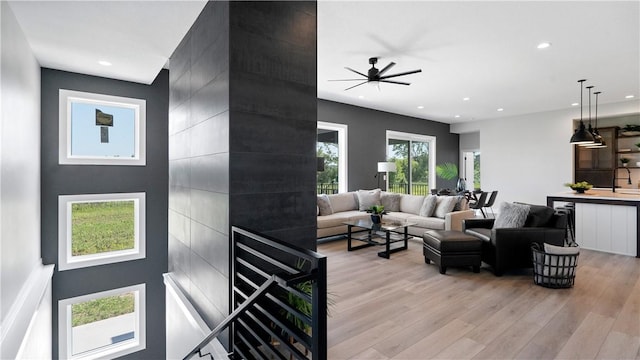 living room with ceiling fan and light wood-type flooring