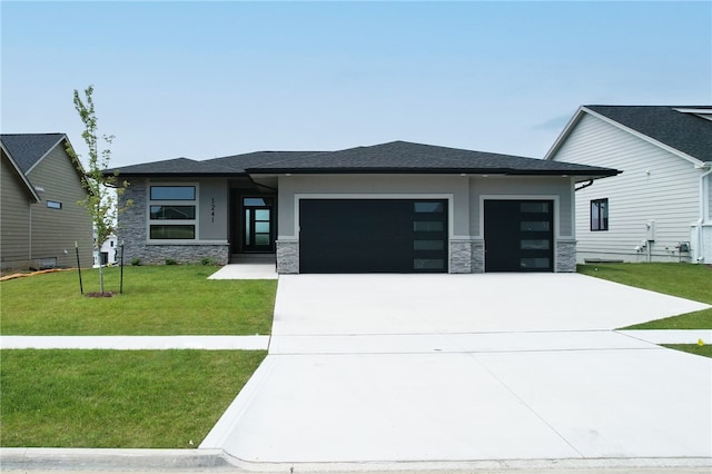 prairie-style house featuring a garage and a front lawn