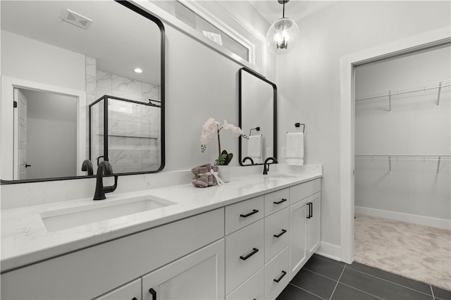 bathroom with tile patterned flooring, vanity, and a shower with shower door