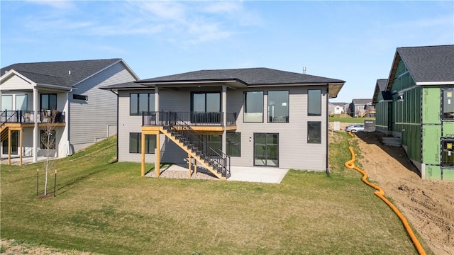 back of house with a deck, a yard, and a patio