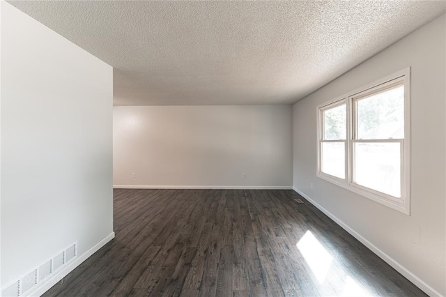 unfurnished room with a textured ceiling and dark wood-type flooring