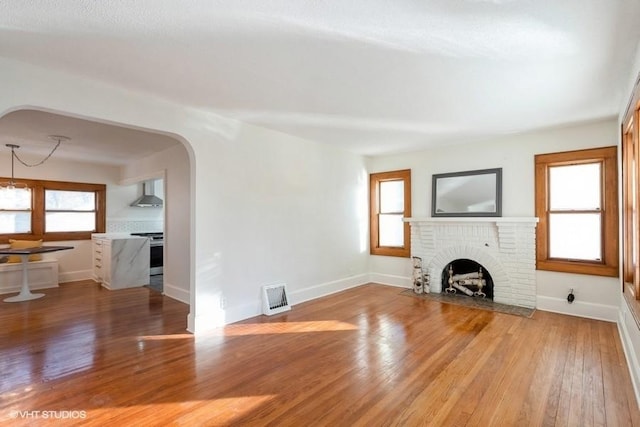 unfurnished living room featuring a fireplace, hardwood / wood-style floors, and a wealth of natural light