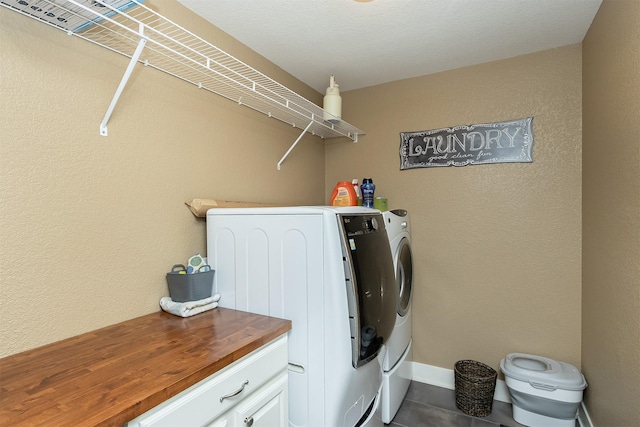 clothes washing area with washer and dryer and dark tile patterned flooring