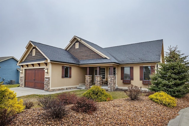 craftsman house with central air condition unit, covered porch, and a garage