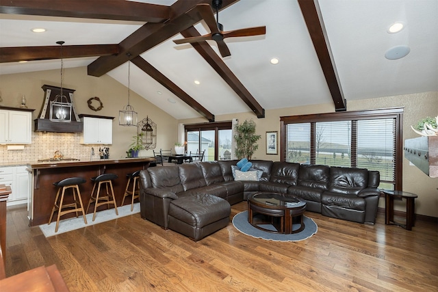 living room with vaulted ceiling with beams, ceiling fan, and wood-type flooring