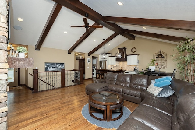 living room with hardwood / wood-style floors, lofted ceiling with beams, ceiling fan, and sink