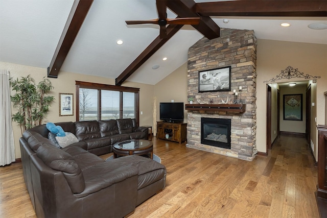 living room featuring a fireplace, vaulted ceiling with beams, and light hardwood / wood-style floors