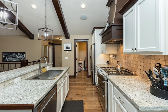 kitchen featuring beam ceiling, an island with sink, appliances with stainless steel finishes, and sink