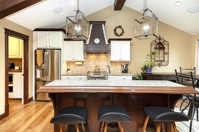 3513 Sunstone Ct SE, Altoona, IA 50009 - kitchen with appliances with stainless steel finishes, custom exhaust hood, backsplash, white cabinetry, and a breakfast bar