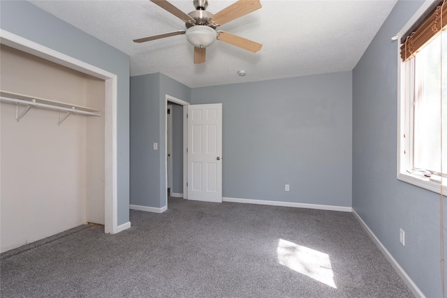 unfurnished bedroom featuring a textured ceiling, carpet floors, a closet, and ceiling fan