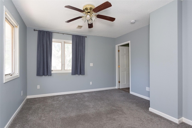 unfurnished room featuring dark carpet and ceiling fan