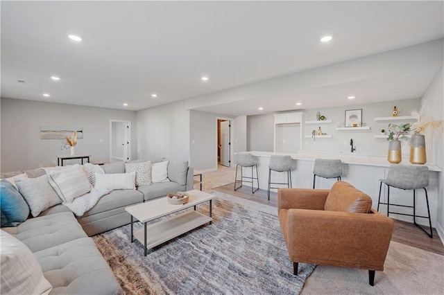 living area featuring recessed lighting, light wood-type flooring, and wet bar