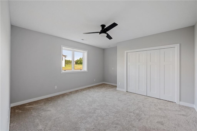 unfurnished bedroom with carpet, baseboards, a closet, and ceiling fan