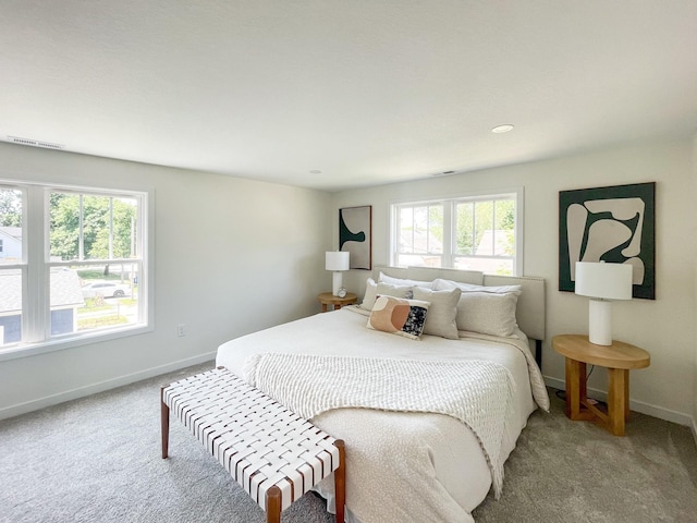 bedroom featuring light carpet and multiple windows