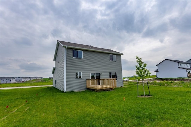 back of house featuring a lawn and a wooden deck