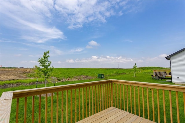 wooden terrace featuring a lawn and a rural view