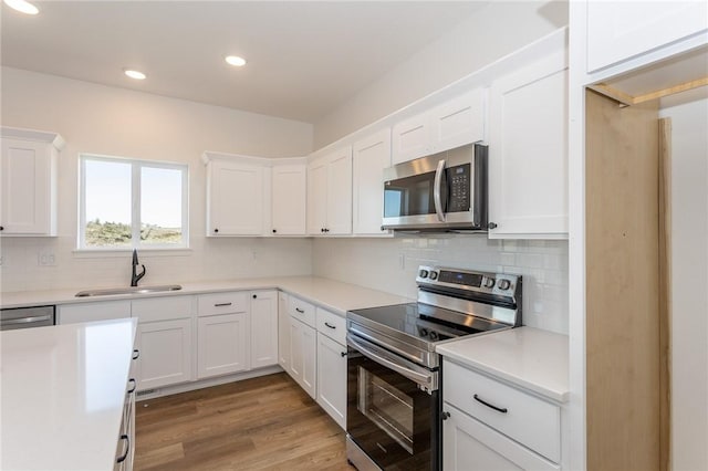 kitchen with sink, white cabinets, and appliances with stainless steel finishes