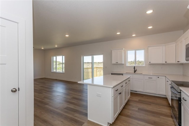 kitchen featuring white cabinetry, a kitchen island, dark wood-type flooring, and electric stove