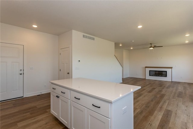 kitchen with light hardwood / wood-style floors, ceiling fan, a center island, and white cabinetry