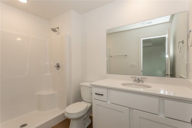 bathroom with vanity, hardwood / wood-style flooring, toilet, and walk in shower