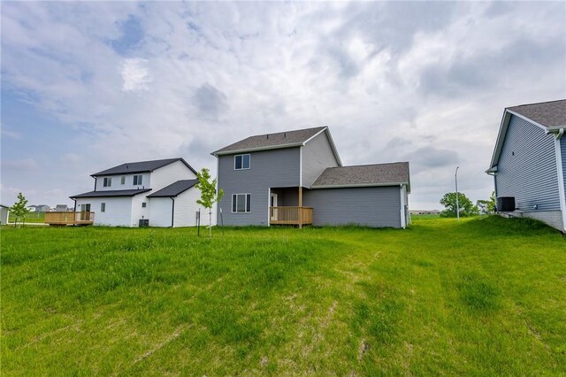 rear view of house with a deck and a lawn